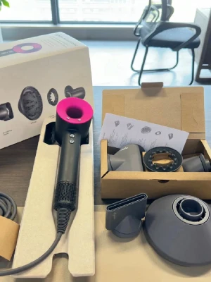 Dyson Supersonic hårfön svart/rosa - Dyson Supersonic hårfön i svart med rosa ring, levereras med flera munstycken. Modern design med rund form och magnetiska tillbehör för styling. Perfekt för dig som vill ha en kraftfull och innovativ hårtork.