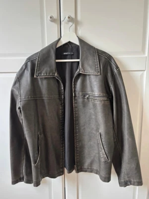 Snygg skinnjacka - Supersnygg svartgrå skinnjacka. I jättefint skick! Lite oversized men sitter supersnyggt, perfekt till sommaren! 
