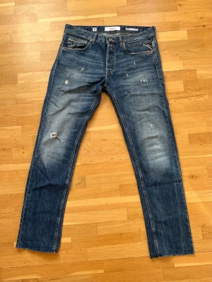Replay Grover  - Säljer ett par blå Replay Grover jeans med fet tvätt och slitningar. Jeansen är i strl W32 L32 och är avklippta nertill.
