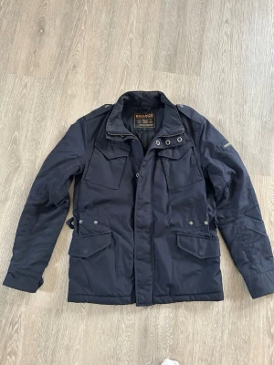 Woolrich Fieldjacka - Woolrich Fieldjacka Storlek: S (jag är 178 cm, se bilden) Färg: Marinblå Passform: Sitter perfekt för storlek S Skick: 9/10, använd men fortfarande i perfekt skick Nypris: 450 € Jag skickar inom 24 timmar! 📦