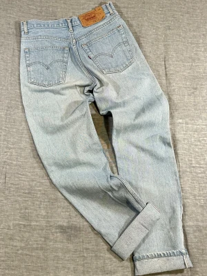 Vintage Levi’s 501 Made in USA Light Wash Jeans W30 90s Straight Leg Denim - Classic Levi’s 501 light wash denim with button fly and straight leg fit. Made in USA pair with a great worn-in vintage fade.  Some small signs of wear including about five small dots near the front right pocket and slight staining on the right leg (see photos). No structural damage.  Measurements (cm, laid flat): Waist 36 Rise 28 Thigh 27 Knee 21 Leg opening 18 Inseam 80 Back width 47  Great everyday vintage Levi’s.