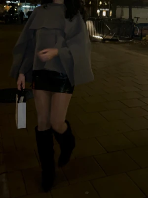 Grå oversized kappa med volang - Säljer en grå oversized kappa med volangdetaljer och vida ärmar. Jackan har en modern och trendig look, perfekt för dig som vill sticka ut. Den är tillverkad i ett mjukt material och har en lös passform som ger en cool siluett.