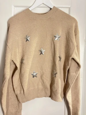 Stickad tröja med stjärnor från Gina - Beige stickad tröja, stjärn detaljer av paljetter. Aldrig använd!! 💗