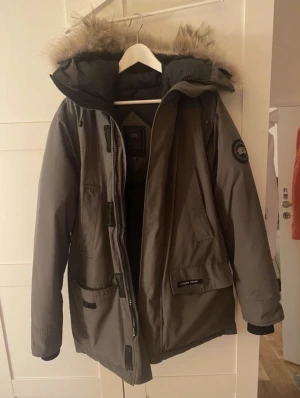 Grå Canada Goose parkas med pälskant - Jackan har använts ett par år och har ett litet mindre hål vid högra fickan nypriset när den köptes va nog runt 14-17 tusen men eftersom den har använts vilket är synligt så säljer jag inte den för så mycket👍