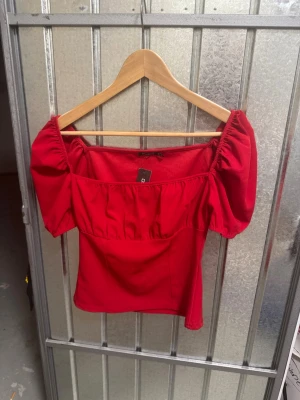Röd topp - Superfin röd topp! Helt oanvänd. Storlek 38. Går att ha off shoulder eller som en vanlig topp.