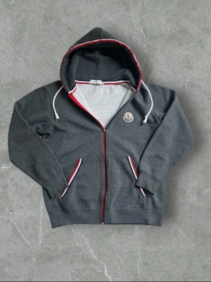 Moncler zip up - Riktigt fet moncler zip up som inte har blivit använd mycket och har inga skador eller liknande. Sitter perfekt om man är 177-188 beroende på hur mycket man väger 