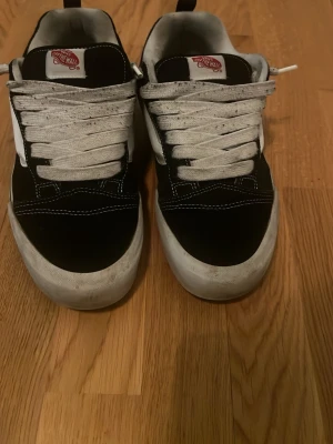 Svarta Vans sneakers - Klassiska Vans sneakers i svart med vit sula och vit sidostripes. Skorna har vita skosnören och detaljer i mocka och canvas. Perfekta för en streetwear-look och funkar till det mesta. Tidlös design med låg profil och bekväm passform.