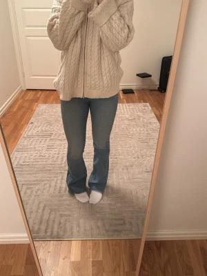 Ljusblå bootcut jeans - Säljer ett par ljusblå bootcut jeans med hög midja och klassisk femficksdesign. Jeansen har en snygg utsvängd passform från knät och är tillverkade i ett mjukt denimtyg. Perfekta för en avslappnad och trendig look.