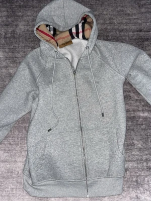 Passar i m också Grå zip-hoodie från Burberry -  Passar i m också Snygg grå hoodie med dragkedja från Burberry. 