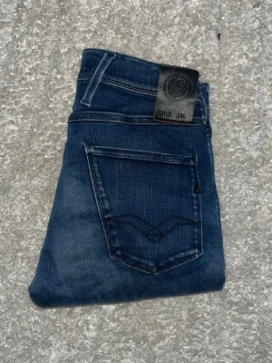 Replay Anbass jeans  - Mörkblåa Replay Anbass jeans med kontrastmönster men en slim passform. Midja 37cm, längd 93cm. JAG SKICKAR EJ FLER BILDER NÄR JAG BÄR JEANSEN! för bättre inblick i passformen rekommenderar jag att googla på modellnamnet. För storleksguide kolla måtten noggrant då jeansen alltid kan vara uppsydda heller krympta och jag ej tar emot returer :) 1,71