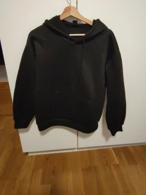 Svart hoodie med leopardstjärna - Cool svart hoodie med huva och känguruficka framtill. På ryggen finns en stor stjärna i leopardmönster som ger en unik touch. Perfekt för dig som vill sticka ut lite extra. Mjuk och skön, passar till det mesta i garderoben. knappast använd, för kort.