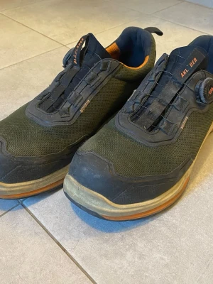 Jobbskor - Säljer ett par svarta jobbskor från Blåkläder med orange detaljer och smart snörningssystem med snurrhjul. Skorna har en robust design med meshmaterial och förstärkta partier runt tån och hälen. Perfekta för dig som jobbar på praktiska jobb. Inga skador