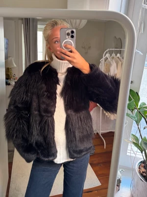Svart fluffig pälsjacka - Säljer en svart, fluffig pälsjacka med långhårig fuskpäls och rak passform. Den varierar i långt och kort pälsmönster på ett häftigt sett⭐️ Den har ett litet hål på framsidan under pälsen, men det är inget synligt och enkelt att sy igen. ❤️