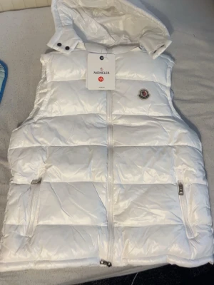 Vit moncler väst med nfc scan - Väldigt fet vit  moncler väst där man kan ta bort luvan, går även att skanna moncler loggan