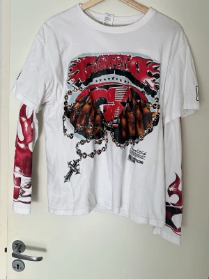 Vit långärmad t-shirt med tryck - Unik vit långärmad t-shirt från Westside med stort grafiskt tryck framtill i rött, svart och brunt. Ena ärmen har ett rött och vitt mönster som sticker ut och ger en cool kontrast. Tillverkad i mjuk bomull och har en relaxed passform.