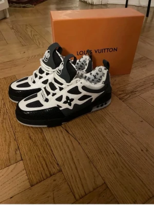 LV Skates - Snygga svartvita LV sneakers med ikoniska monogramdetaljer och LV-logga på plösen. Skorna har en chunky sula, meshpaneler och läderdetaljer. Insidan är fodrad med LV-mönster och de har vita och svarta skosnören. Perfekt för dig som gillar exklusiv streetwear. Snabb affär kan pris diskuteras. 