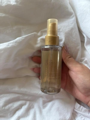 Luxe Oil hårolja 100 ml 40/100 kvar  - Säljer en Luxe Oil hårolja i genomskinlig plastflaska med guldfärgad pump och etikett. Flaskan rymmer 100 ml och är perfekt för att ge håret extra glans och näring. Oljan är lätt i konsistensen och enkel att applicera tack vare sprayfunktionen. 40% av podukten kvar