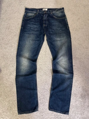 Dobber Jeans ”The Postman” - Säljer ett par archive dobber jeans i modellen ”The Postman” i färgen ”Dodger Blue”. Jeansen har riktigt feta slitningar som är väldigt efterfrågat. Storlek W34L34