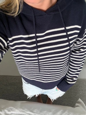 Marinblå randig stickad hoodie - Säljer en marinblå stickad hoodie med vita  ränder. Aldrig använd