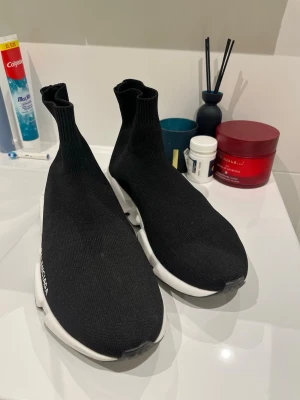 Balenciga  - Storlek 43 Svarta  sneakers med vit  sula och stickad ovandel i textil. Strumpliknande passform och logga på sidan. Snygg och futuristisk design som sticker ut.