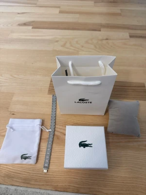 Silver Lacoste armband  - Så jag säljer detta Lacoste armaband eftersom jag har aldrig haft på mig den och den får ba damm på sig, så ja tänker att någon annna skulle kunna andvända den på ett bättre sätt men också få den för ett bättte pris. Kontakta mig för frågor 