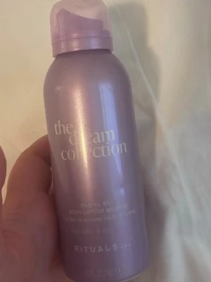 Lila body lotion mousse Rituals - The Dream Collection Pastel Sky body lotion mousse från Rituals i en skimrande lila flaska. Moussen återfuktar huden och har en mjuk, fräsch doft. Praktisk sprayflaska i metall med plastlock, perfekt för dig som vill ha en lyxig känsla i din hudvårdsrutin.