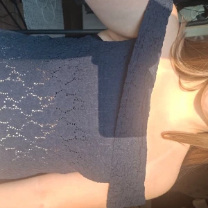 Mörkblå offshoulder spets-topp - Snygg mörkblå offshoulder topp i spets med bred krage. Engångsanvänd. Toppens material är spetsig polyester och den är ärmlös med en axelbandslös design. 