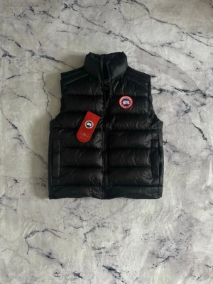 Canada Goose Väst - En mycket fin knappt använd väst med inga defekter. Plagget köptes som present men kom aldrig till användning därmed tänkt ekat bli av med den, sitter även fint i storlek!  Priset kan diskuteras:)