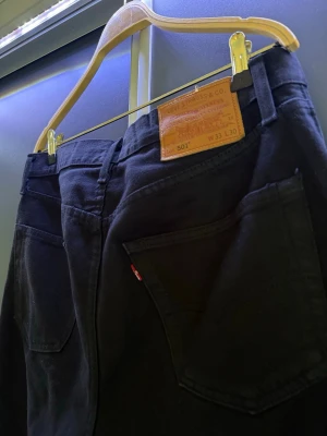 Svarta Levi's  - Säljer ett par svarta Levi's 501 jeans med rak passform och avklippt benslut. Bra skick. Skriv om du vill ha mått och längd eller vid andra frågor!