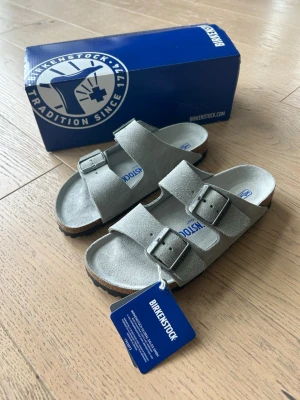 Grå mockasandaler från Birkenstock - Säljer dessa snygga grå sandaler från Birkenstock. Köptes i butiken i London men tyvärr blev storleken fel, går inte att lämna tillbaka, därav att jag säljer dom. Aldrig använda. Hör av dig vid frågor🌸