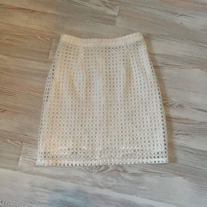 Vit kjol från Monki - Säljer en snygg vit kjol från Monki med ett unikt cirkelmönster. Kjolen har en dragkedja baktill och är perfekt för en stilren look. Den är fodrad för extra komfort.