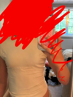 Beige croppad linnetopp från Avora - Trendig beige croppad linnetopp med rund hals och smala axlar. Toppen har en tight passform och är tillverkad i mjukt bomullsmaterial. Perfekt för sommardagar och enkel att styla med jeans eller kjol.