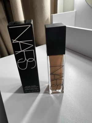 NARS Natural Radiant Foundation M1 - NARS Natural Radiant Longwear Foundation i nyansen M1 Patagonia. Kommer i en stilren glasflaska med svart lock och tydlig logga. Flytande foundation som ger en naturlig finish och lång hållbarhet. Innehåller 30 ml.“Den testades endast på handen