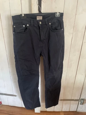 Svarta slim fit jeans från Morris - Säljer ett par svarta jeans från Morris Stockholm, modell James Slim Cut. Jeansen har fem fickor, silverfärgade nitar och knapp, samt en smal passform som sitter snyggt. Perfekta för dig som gillar stilrena och klassiska jeans.strl 31-32