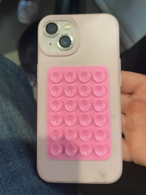 Ljusrosa mobilskal med popsocket - Snyggt ljusrosa mobilskal med en rosa popsocket på baksidan som har fyra sugproppar. Skalet är gjort i mjukt silikonmaterial och passar perfekt till dig som vill ha ett skal som både skyddar och är praktiskt. Popsocketen gör det enkelt att hålla mobilen.