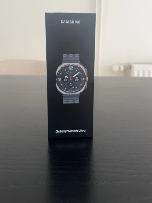 Samsung Galaxy Watch Ultra smartklocka - Samsung Galaxy Watch Ultra är en smartklocka med sportig design i svart och grått. Klockan har en rund urtavla med digital display och robust armband. Funktioner som LTE, Bluetooth, Wi-Fi och GPS ingår. Perfekt för dig som vill ha koll på hälsa och notiser direkt på handleden.