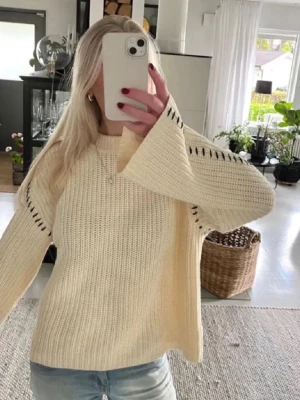 Vit stickad tröja med detaljer - Sååå snygg och populär krämvit stickad tröja med detaljer. Tröjan har en rak passform, rund halsringning och är gjord i ett mjukt, grovstickat material. 💕💕