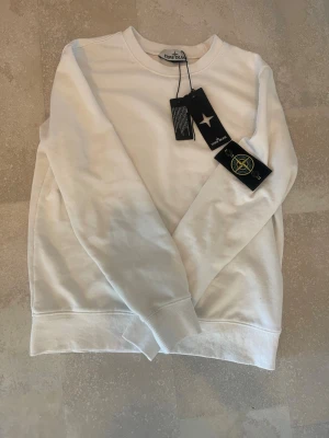 Vit sweatshirt från Stone Island - Helt ny Stone Island tröja, har endast provat ett fåtal gånger. Säljer pågrund utav att den inte passar mig. Storlek S