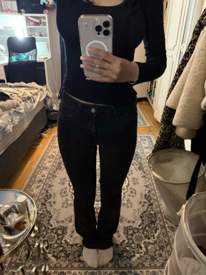 Svarta bootcut jeans - Säljer ett par svarta bootcut  och klassisk femficksdesign jeans. Jeansen har normal midja och stängs med knapp och dragkedja. Perfekta till en enkel topp eller hoodie för en clean look.