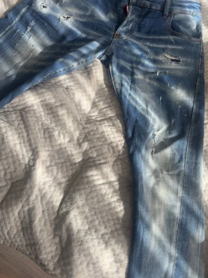 Ljusblå slitna jeans Dsquared2 - Fina jeans till salu står storlek 48 men de har krympt i tvätten för fel tvätt av morsan. Jag är 173 och väger 80kg och de sitter bra på mig så skulle tipsa till 75-80kg och längden kan va lite längre ungefär 175