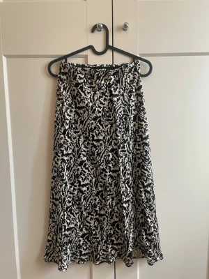 Svart/vit satinkjol - Mönstrad Satinkjol från HM i stl XS men skulle säga att den passar mer som en S🌸