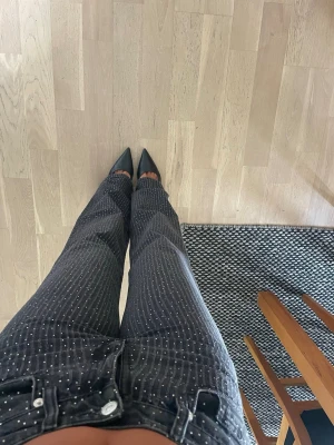 Svarta raka glitterjeans  - Säljer ett par svarta jeans med raka ben och glittriga strassdetaljer över hela byxan. 