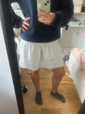 Vit kortkjol Gina triccot✨ - Söt vit kortkjol med små guld prickar på. Kjolen har en avslappnad passform och resår i midjan för extra komfort. Perfekt om man gillar luftiga sommarkläder.