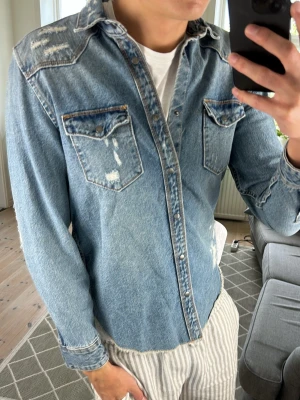 Jeansskjorta/Overshirt Blå - Super snygg jeansskjorta med tilltänkta och stilrena slitningar!  Mått:A:48 B:41 C:43 D:64 (cm)  Skriv vid fundering!😇🙌 