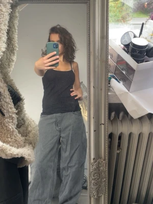 Baggy grå jeans från Empyre - Säljer ett par riktigt baggy grå jeans från Empyre . Jeansen har bred passform och cool retro-vibe med en färgglad patch bak. Perfekta för dig som gillar streetstyle och vill ha något bekvämt och snyggt.