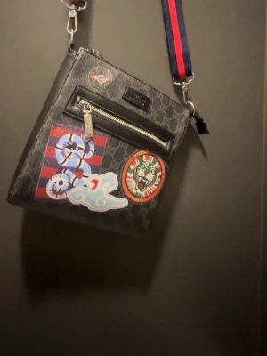 Svart axelväska med patchdetaljer - Säljer för jag ej använder, fr 700 till 350!!