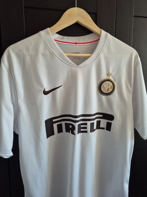 Nikf Vit Inter Milan tröja från 08/09  - Säljer en vit Inter Milan matchtröja från Nike med Pirelli-logga på bröstet och klubbmärke med stjärna. Tröjan har korta ärmar och är tillverkad i ett lätt, ventilerande material som passar perfekt till fotboll eller träning.