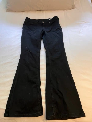Svarta bootcut jeans från Vero Moda - Säljer ett par svarta bootcut jeans från Vero Moda. Jeansen har klassisk femficksdesign, låg midja och utsvängda ben. Materialet är mjukt och stretchigt för extra komfort. 