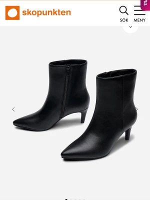 Svarta stövletter med smal klack - Snygga svarta stövletter från Skopunkten med spetsig tå och smal klack. Tillverkade i slätt syntetmaterial med dragkedja på insidan för enkel på- och avtagning. Perfekta för dig som vill ha en stilren och trendig look.