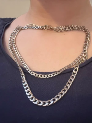 Silverfärgat chunky kedjehalsband - Säljer ett trendigt halsband i silverfärgad metall med chunky kedjelänkar. Halsbandet har två lager i olika tjocklekar för en cool och modern look. Anledningen t att jag säljer är pga att den är silver och jag är en guld tjej. 